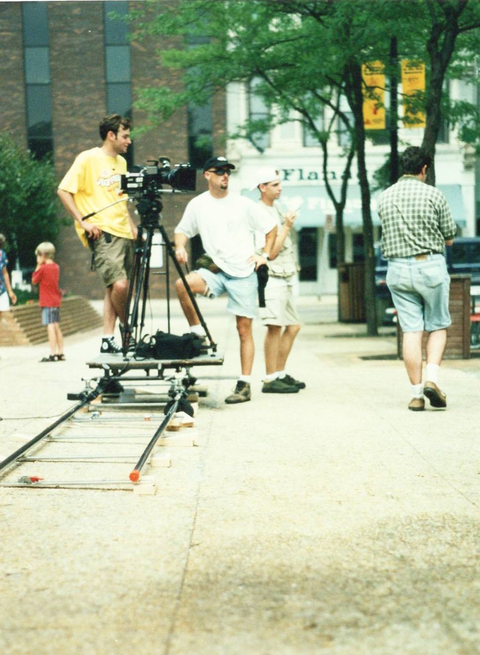 a camera team of three guys setting up the shot on a dolly track